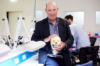 Man holding model of a skull in a science lab. Man holding model of a skull in a science lab.