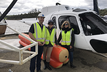 Sheryl Frame and 2 colleagues standing next to a helicopter. Sheryl Frame and 2 colleagues standing next to a helicopter.