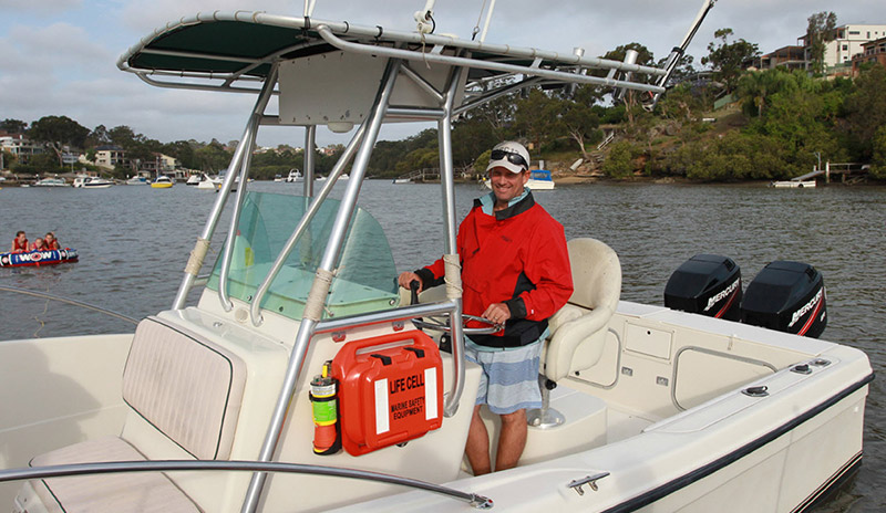 Brightly coloured plastic device attached to the side of a small boat. It is similar in size and shape to a briefcase, but with a cylinder shaped part connected to one side. Brightly coloured plastic device attached to the side of a small boat. It is similar in size and shape to a briefcase, but with a cylinder shaped part connected to one side.