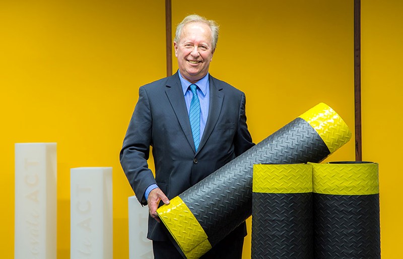 Person holding a rolled rubber mat with diamond plate style grip markings Person holding a rolled rubber mat with diamond plate style grip markings