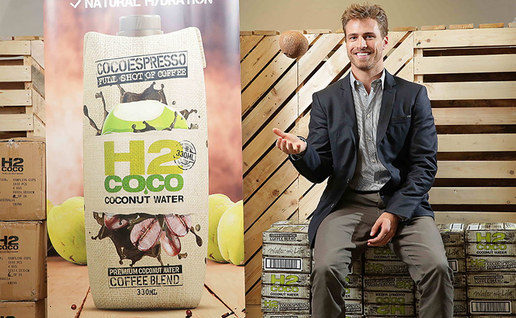 Person sitting on food crate throwing and catching coconut Person sitting on food crate throwing and catching coconut