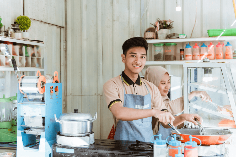 A man and woman prepare food in their restaurant