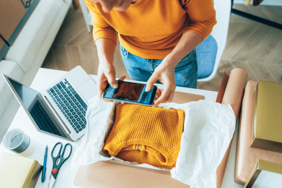 A woman takes a photo of a jumper in a package