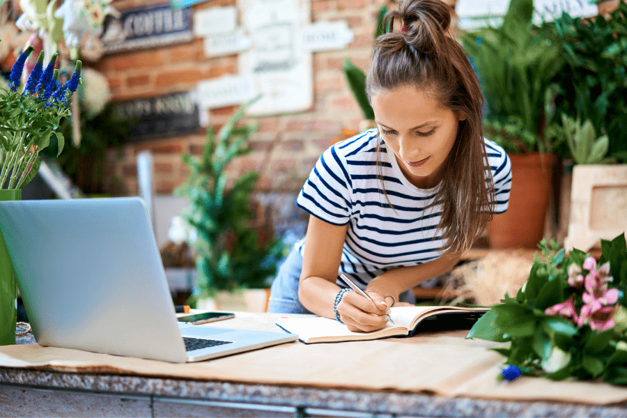 A florist ticks of a list of tasks in her notebook