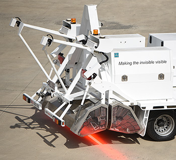 Truck with contraption on back that is projecting a bright beam of light on the ground.