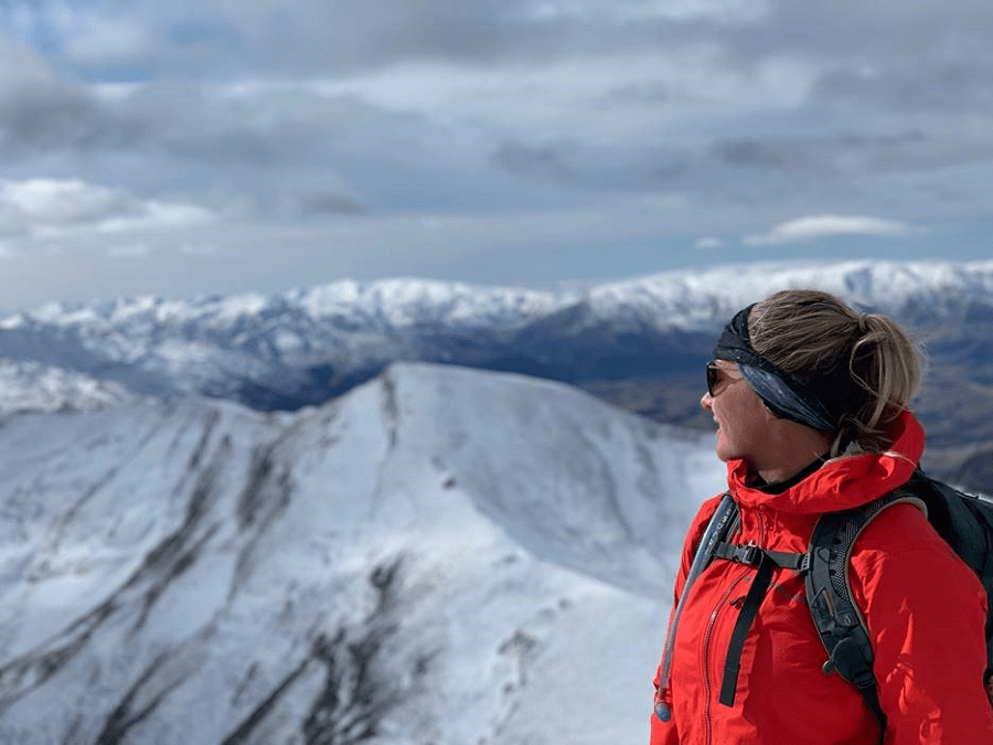 Person looking over snow covered moutain tops.