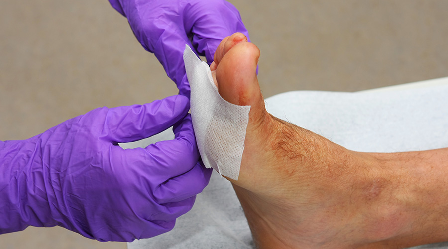 Doctor applying bandage to patients foot