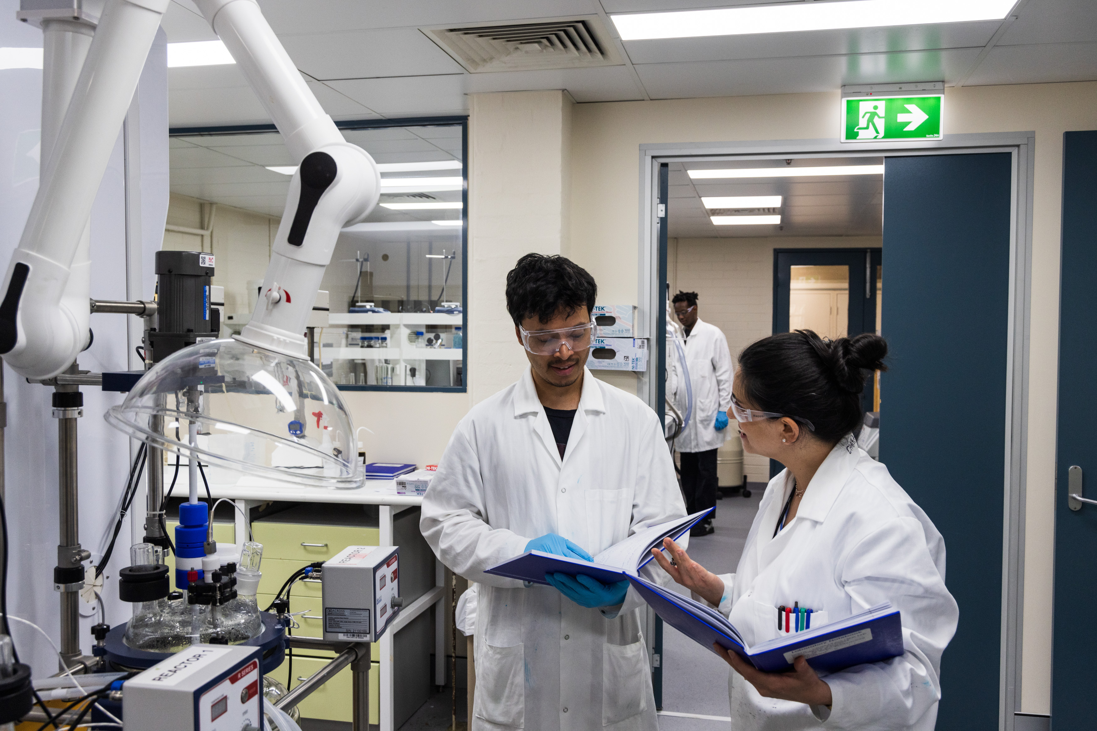 Image of two people in lab coats collaborating in a lab.