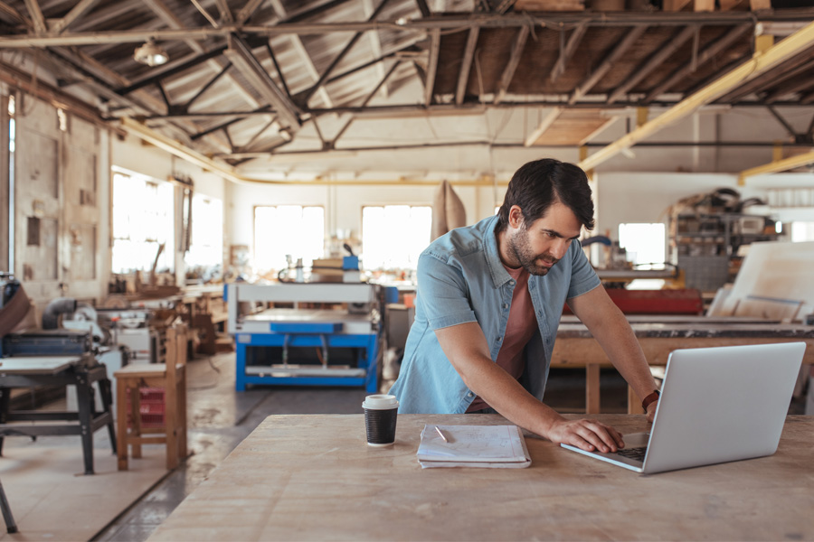A man on his laptop in a trade workshop